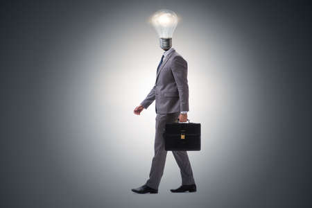 Businessman in bright idea concept with lightbulb headの写真素材