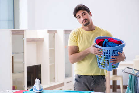 Handsome man husband doing laundering at homeの写真素材