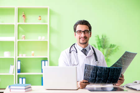 Doctor radiologist looking at x-ray scan in hospitalの写真素材