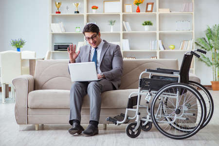 Dsabled businessman on wheelchair working homeの写真素材