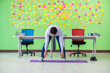 Man in the office with many conflicting priorities doing exercisの写真素材