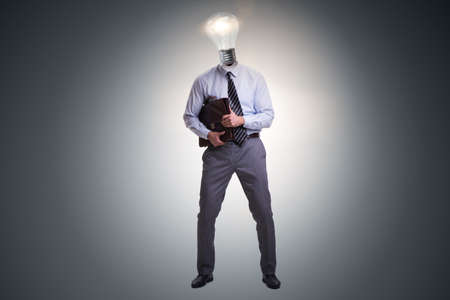 Businessman in bright idea concept with lightbulb headの写真素材