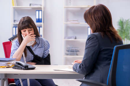 Injured employee visiting lawyer for advice on insuranceの写真素材