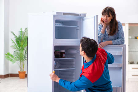 A mechanic repairing fridge at customer houseの写真素材