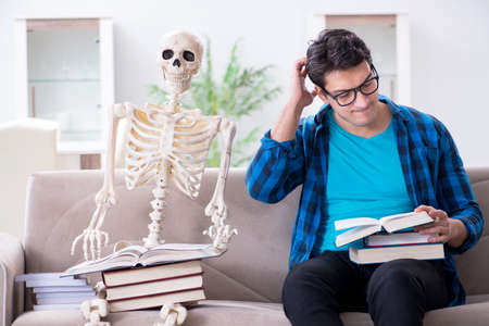 Student studying with skeleton preparing for examsの写真素材