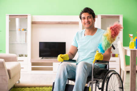 Disabled man on wheelchair cleaning house