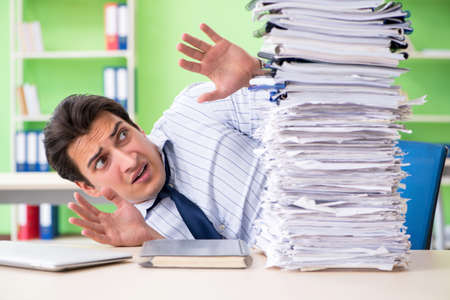 Businessman having problems with paperwork and workloadの写真素材