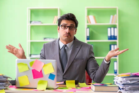 Businessman unhappy with many conflicting priorities sitting inの写真素材