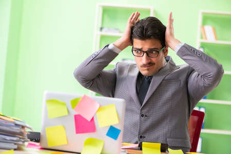 Businessman unhappy with many conflicting priorities sitting inの写真素材