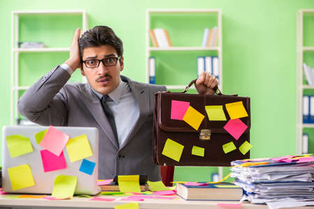 Businessman unhappy with many conflicting priorities sitting inの写真素材