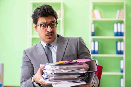 Businessman unhappy with many conflicting priorities sitting inの写真素材