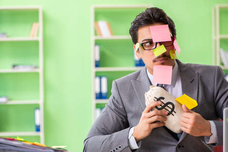 Businessman unhappy with many conflicting priorities sitting inの写真素材