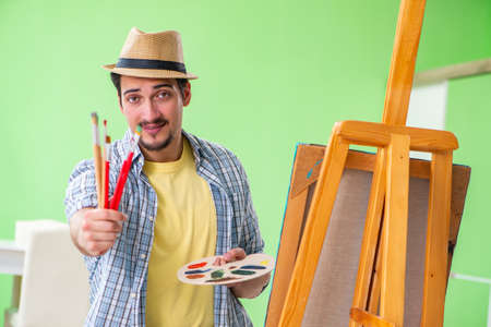 Young male artist working on new painting in his studioの写真素材
