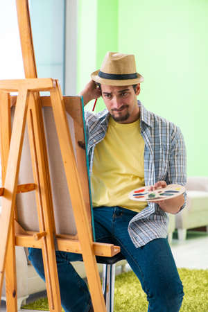 Young male artist working on new painting in his studioの写真素材