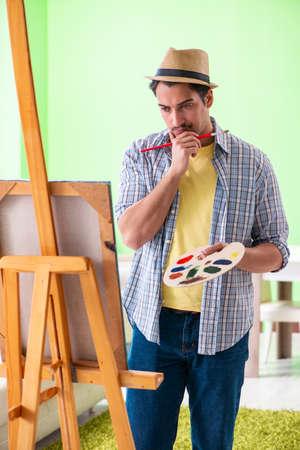 Young male artist working on new painting in his studioの写真素材