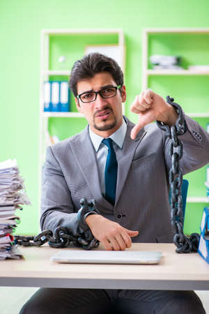 Employee chained to his desk due to workloadの写真素材