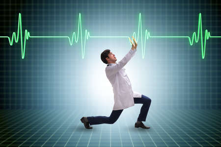 Doctor cardiologist supporting cardiogram heart lineの写真素材