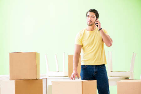 Young handsome man moving in to new house with boxesの写真素材
