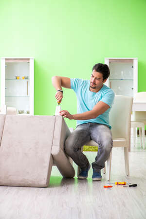 Man repairing furniture at homeの写真素材