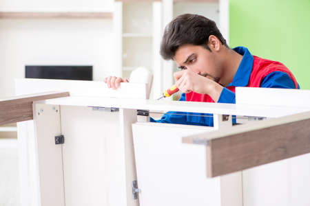 Repair contractor repairing broken furniture at homeの写真素材