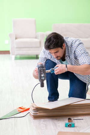Man laying flooring at homeの写真素材