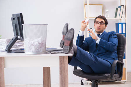 Young handsome businessman employee working in office in paperwoの写真素材