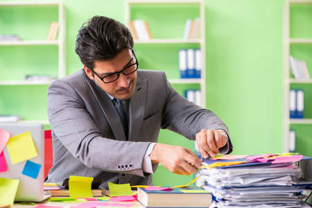 Businessman unhappy with many conflicting priorities sitting inの写真素材