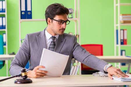 Young handsome lawyer working in the officeの写真素材