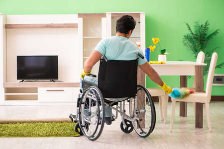 Disabled man on wheelchair cleaning houseの写真素材