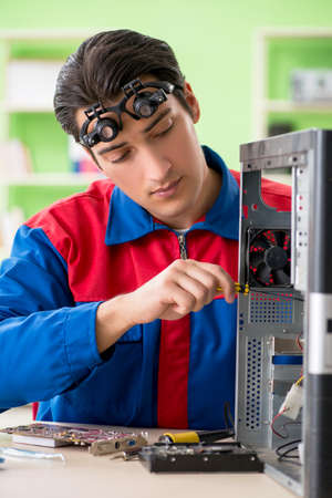 Computer engineer repairing broken desktopの写真素材