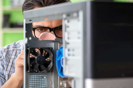 Computer engineer repairing broken desktopの写真素材
