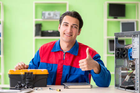 Computer engineer repairing broken desktopの写真素材