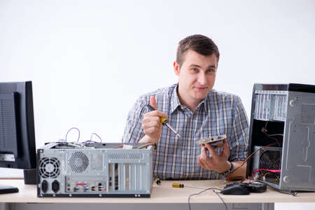 Young technician repairing computer in workshopの写真素材