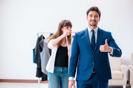 Professional tailor taking measurements for formal suitの写真素材