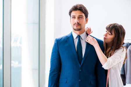 Professional tailor taking measurements for formal suitの写真素材