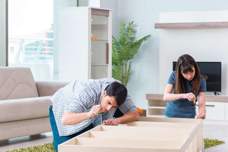 Young family assembling furniture at new houseの写真素材