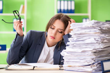Young female employee very busy with ongoing paperworkの写真素材