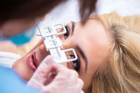 Female ophthalmologist is checking up female patient in eye doct