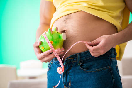 Man measuring body fat with tape measure in dieting concept