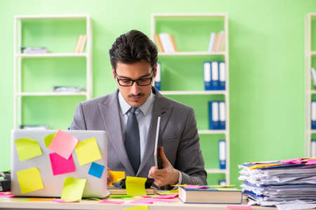 Businessman unhappy with many conflicting priorities sitting inの写真素材
