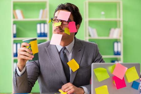 Businessman unhappy with many conflicting priorities sitting inの写真素材