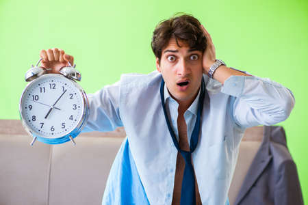 Employee in the bedroom being late for his job in time managemenの写真素材