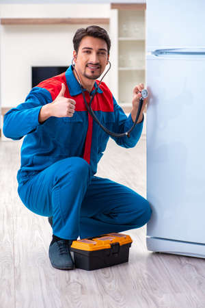 Professional contractor repairing broken fridgeの写真素材