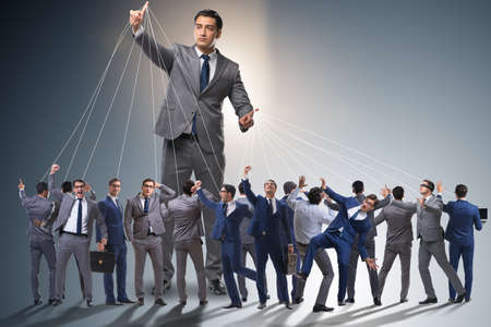 Boss employee manipulating his staff in business conceptの写真素材