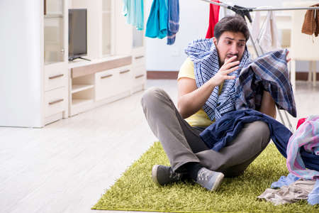 Handsome man husband doing laundering at homeの写真素材