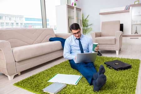 Businessman taking work home and working overtimeの写真素材