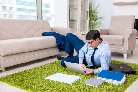 Businessman taking work home and working overtimeの写真素材