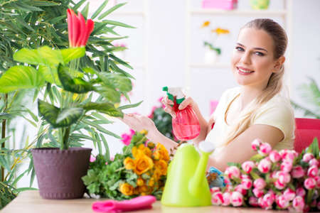Young woman watering plants in her gardenの写真素材