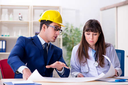Doctor discussing new hospital plan with architect