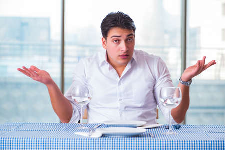 Handsome man alone in restaraunt on dateの写真素材
